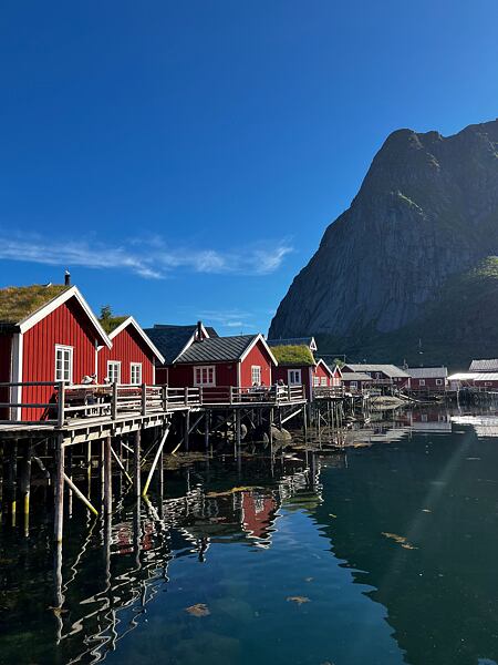 Vesnička Reine s typickými červenými rybářskými domky na vodě, kterým se říká rorbuer (dnes většinou sloužící jako ubytování pro turisty) 