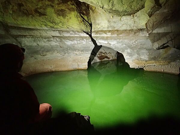 Odtokové jezírko v Atmosu obarvené fluoresceinem pro stopovací zkoušku